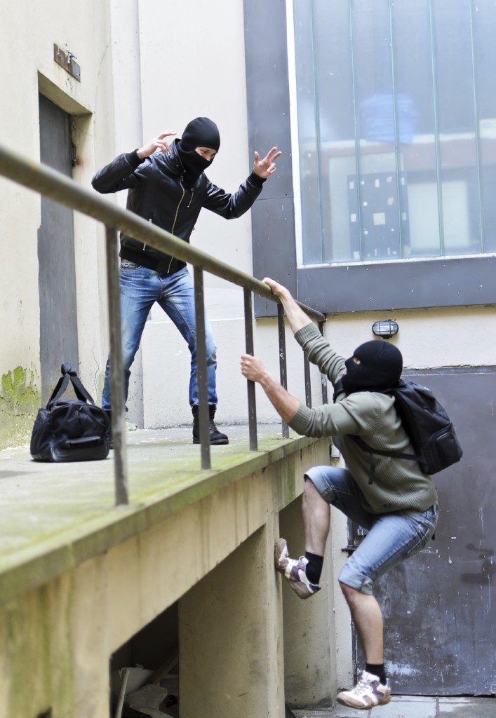 Escape from a robbery. One tries to help another to climb the rails.